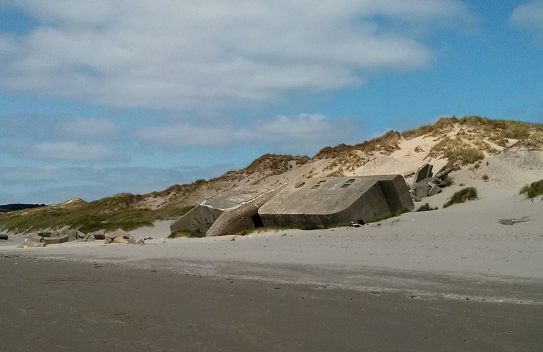 Resten van een betonnen bunker op het strand nabij Le Touquet-Paris-Plage (foto: Wikimedia Commons).