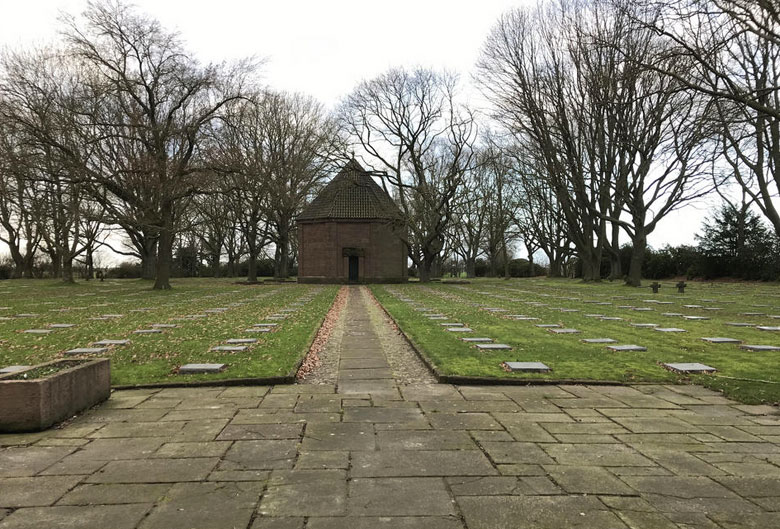 De 40 gesneuvelde Duitsers, die in 1917 op de Tuimelare verbleven en er werden begraven, rusten nu onder 4 plat liggende stenen, in de 6de rij, rechts van dit geplaveide wandelpad naar het centrale mausoleum van Menen Wald. .