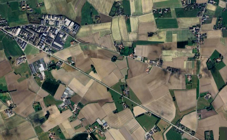 Luchtfoto van de Tuimelarestraat tussen de Oude Heirweg rechts en het industrieterrein links (Bron: Google Satellite View).